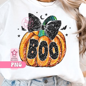 Puede incluir: Sudadera blanca con una calabaza naranja brillante, un lazo negro y la palabra "BOO". El diseño incluye estrellas, murciélagos y una luna creciente. También incluye el texto "FREE DESIGNS INCLUDED!" y "PNG", ideal para Halloween.