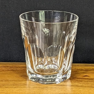 May include: A clear glass tumbler with a faceted design. The glass has a rounded bottom and a straight, slightly flared top.