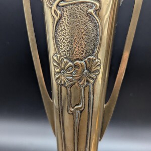 K&ouml;nnte beinhalten: Zwei antike Messingvasen mit kunstvollen Jugendstil-Designs. Die Vasen haben eine geh&auml;mmerte Textur und zeigen florale Motive.