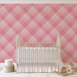 Puede incluir: Una cuna blanca con una falda blanca con volantes y un caballo de balancín delante de un papel tapiz a cuadros rosa y blanco.