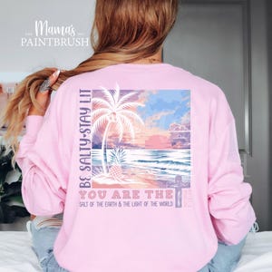 This “Be Salty, Stay Lit” Christian PNG design inspired by Matthew 5:13–16 features a peaceful tropical sunset, palm trees, ocean waves, and a cross—symbolizing faith, light, and God’s calling for believers to shine in the world. With its soft pastel coastal colors and uplifting Bible verse message, this digital download is perfect for creating faith-based apparel, gifts, and home décor.
