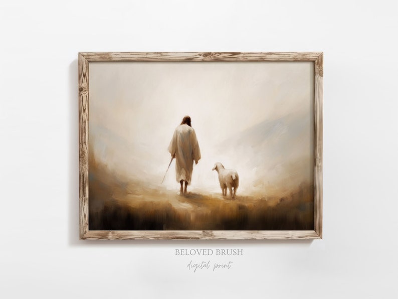May include: A painting of a man in a white robe walking with a lamb in a misty landscape. The painting is framed in a light wood frame. The text "BELOVED BRUSH digital print" is below the frame.