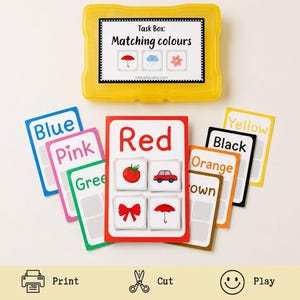 May include: A yellow plastic storage case containing a color matching learning activity. The set includes multiple rectangular cards with color names and corresponding illustrations, such as a red tomato, car, bow, and umbrella on the central card.