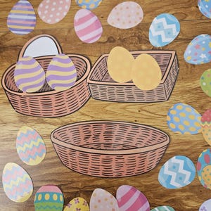 May include: An assortment of colorful Easter egg cutouts with various patterns, including stripes, polka dots, and zigzags, scattered around three wicker baskets. The eggs are in shades of blue, pink, yellow, and green, set against a wooden background.