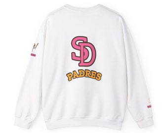 May include: White sweatshirt featuring the San Diego Padres logo on the back. The logo is a pink "SD" with an orange outline, and the word "Padres" is below it. A baseball bat and ball graphic is on the left sleeve. The sweatshirt is a crew neck.