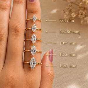 May include: Five gold rings with marquise-cut clear stones in varying sizes. The rings are labeled with dimensions: 8x4 mm, 9x4.50 mm, 10x5 mm, 12x6 mm, and 14x7 mm. Each ring features a thin gold band and a single elongated marquise-cut stone.