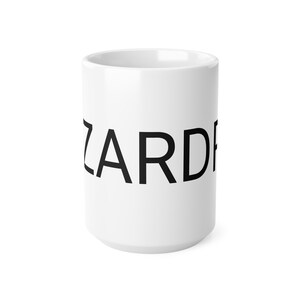 May include: A white ceramic mug with the word 'ZARD' printed in bold, uppercase, black sans-serif font. The mug is a standard 11 oz size and is shown from a slightly angled view against a white background. The mug is a simple, clean design, suitable for everyday use or as a gift.