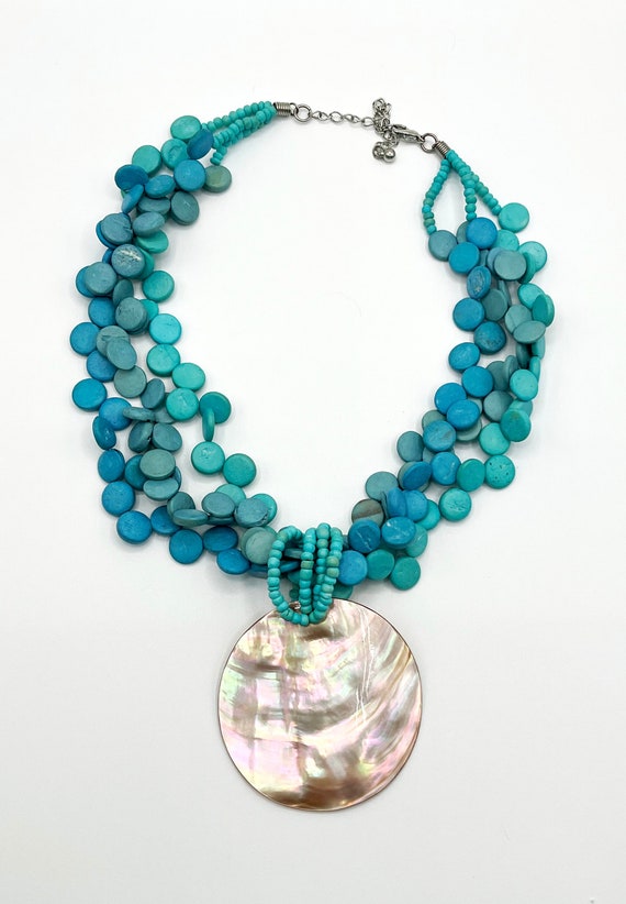 Three Strands of Round Blue Beads with a Round Mot