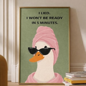 May include: Framed art print showing a duck in sunglasses and a pink towel wrap, with an orange beak, against a green backdrop. The text reads, "I lied. I won't be ready in 5 minutes."