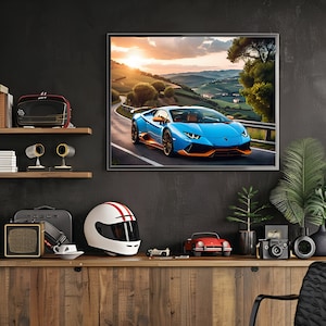 May include: A blue and orange Lamborghini sports car driving on a winding road with a sunset in the background. The car is framed in a black picture frame and hanging on a dark wall.