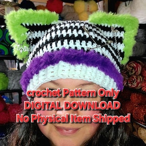 May include: A handmade crochet hat with a black and white houndstooth pattern, accented with green and purple faux fur trim. The hat features decorative safety pins and a bat charm. The text on the image reads "crochet Pattern Only DIGITAL DOWNLOAD No Physical Item Shipped."