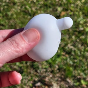 May include: White silicone bottle stopper with a small spout on the side.