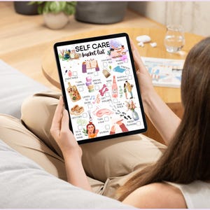 May include: A digital tablet displaying a self-care bucket list with illustrations of various activities, such as reading, taking a bath, and listening to music. The list includes items like paint nails, girl's trip, special treats, read, warm bath, stretch, watch a rom com, wine, lift weights, take a walk, fresh flowers, do a face mask, journal, and take a nap.