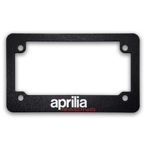May include: Black license plate frame with the word "aprilia" in white and "RACING" in red. The frame has a textured surface and four mounting holes.