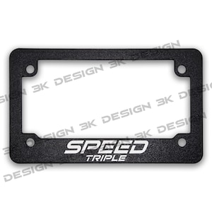 Puede incluir: Marco de matr&iacute;cula rectangular negro con las palabras "SPEED TRIPLE" en blanco. El marco tiene cuatro orificios de montaje y una superficie texturizada. Las palabras "3K DESIGN" est&aacute;n impresas alrededor del marco.