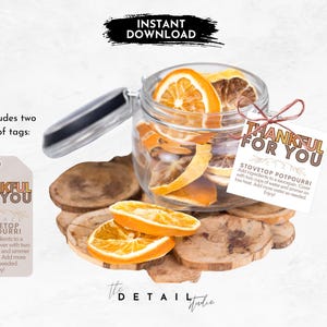 May include: Two printable gift tags with the text "Thankful for You" in orange and brown lettering. The tags include instructions for making a stovetop potpourri with dried orange slices.