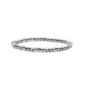 May include: A silver beaded bracelet with a simple design. The bracelet is made of small, round beads that are strung together on a thin cord.