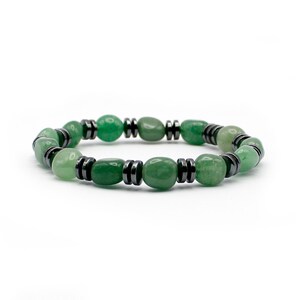 May include: A green and black beaded bracelet with oval-shaped green stones and black metal beads.