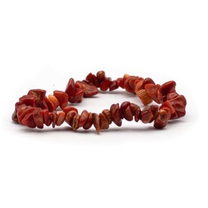 Könnte beinhalten: Ein rotes Korallen-Chip-Armband mit unregelmäßig geformten Perlen.