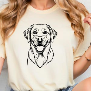 May include: A white t-shirt with a black and white illustration of a Labrador Retriever's head. The dog is smiling with its tongue sticking out.