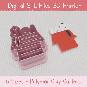 Könnte beinhalten: Digitale STL-Dateien zum 3D-Druck eines Hundehaus-Ausstechers mit einem Hund oben drauf. Der Ausstecher ist rosa und der Hund ist weiß mit schwarzen Ohren und einer schwarzen Nase. Der Text "6 Größen - Polymer Clay Cutter" befindet sich am unteren Rand des Bildes.