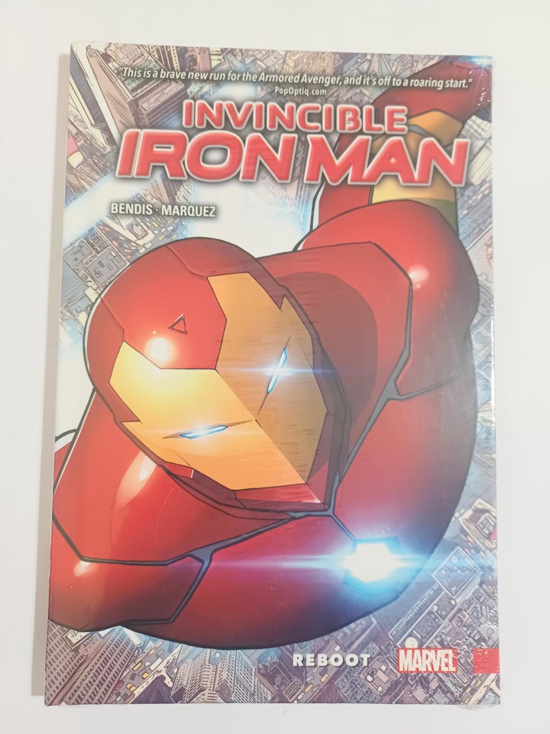 May include: A comic book cover for Invincible Iron Man, featuring a red and gold Iron Man suit in a dynamic pose. The title is prominently displayed with the Marvel logo and the word "Reboot". The cover includes text: "This is a brave new run for the Armored Avenger, and it's off to a roaring start."