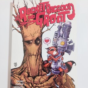 May include: A comic book cover featuring Rocket Raccoon and Groot. Rocket, a raccoon, holds a large weapon, while Groot, a tree-like creature, stands behind him. The title reads "Rocket Raccoon and Groot" in red letters. The Marvel logo is visible.