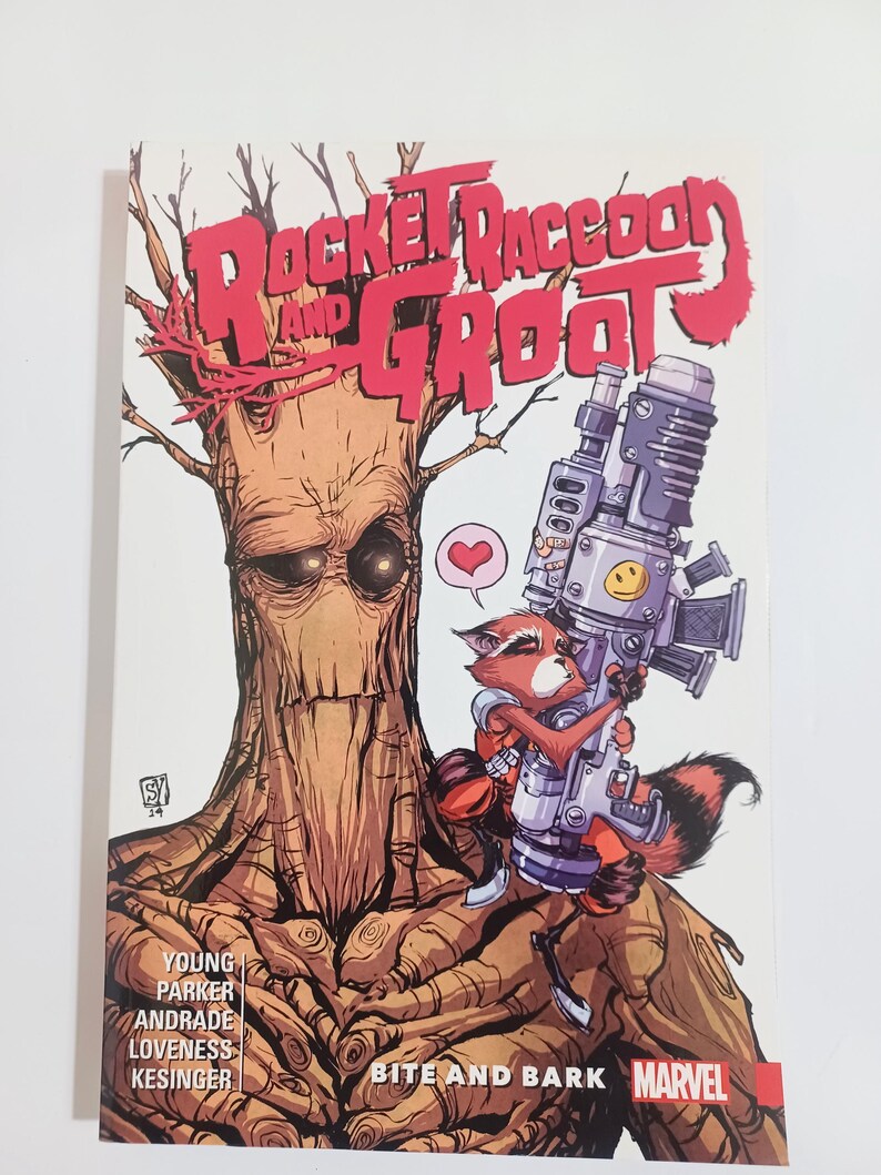 May include: A comic book cover featuring Rocket Raccoon and Groot. Rocket, a raccoon, holds a large weapon, while Groot, a tree-like creature, stands behind him. The title reads "Rocket Raccoon and Groot" in red letters. The Marvel logo is visible.