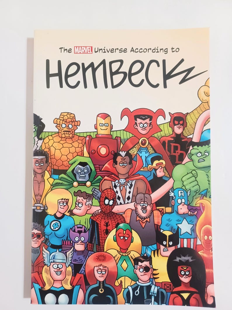 May include: A comic book cover featuring a colorful illustration of numerous Marvel superheroes. The title reads "The Marvel Universe According to Hembec". The characters include Iron Man, Spider-Man, and Captain America.