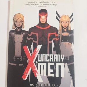 May include: A comic book cover for "Uncanny X-Men" features three costumed characters. The central figure is in a dark red and black suit with a visor. The title is in large white letters with a red "X" overlay. The cover includes text: "VS. S.H.I.E.L.D."