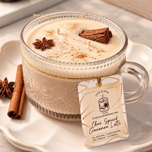 May include: A 340g soy candle in a clear glass mug with a textured pattern, topped with a star anise and a cinnamon stick. A tag reads Casa & Artz, Chai Spiced Cinnamon Latte, 70-80 hours burning time, all natural soy candle, handcrafted in Canada.