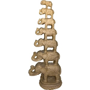 May include: A stack of seven intricately carved golden elephants, each standing on top of the other, creating a decorative tower.
