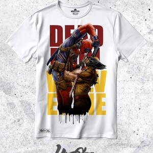 Puede incluir: Camiseta blanca con un estampado gráfico de Deadpool y Wolverine luchando. El texto "DEADPOOL VS WOLVERINE" está impreso en letras rojas, amarillas y negras.