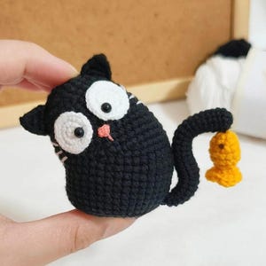 Schema all&#39;uncinetto per un simpatico gatto nero, portachiavi all&#39;uncinetto amigurumi a forma di simpatico gatto, tutorial PDF per ciondolo a forma di gatto per borsa, schema all&#39;uncinetto per un simpatico gatto che inclina la testa