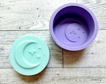 May include: Two silicone moulds for making resin crafts. The moulds are purple and light blue and feature a crescent moon with stars design.