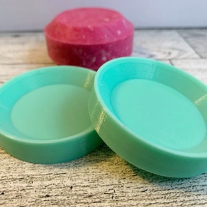 Op de afbeelding: Twee ronde zeepschalen van plastic in turquoise. De schalen zijn lichtjes verhoogd in het midden en hebben een gladde, glanzende afwerking.