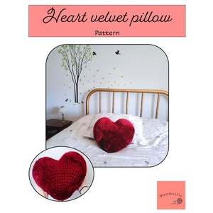 May include: A red heart-shaped velvet pillow on a bed with a white bedspread. The pillow is a crochet pattern. The text "Heart velvet pillow" and "Pattern" is visible in the image.