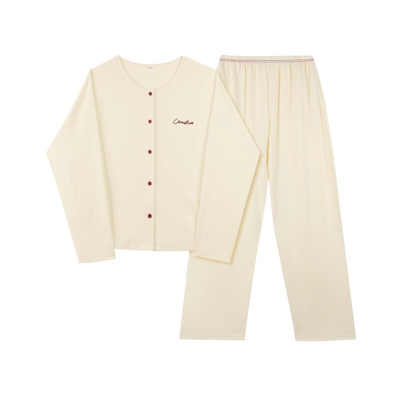 May include: A cream-colored pajama set with long sleeves and pants. The top has a button-up front and the text "Camille" embroidered on the chest.