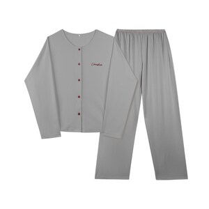 May include: Gray long-sleeved pajama top with button closure and "Cherish" embroidered on the front, paired with matching gray long pants.