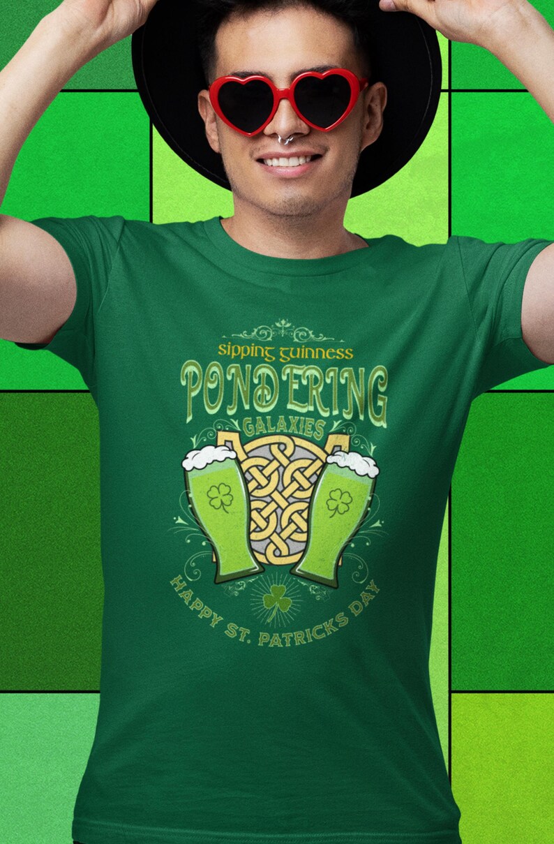 Sipping Guinness, Pondering Galaxies. Happy St. Patrick's day. The Perfect Unisex T-Shirt for the Irish Astrophysics Lover.