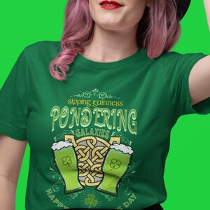 Sipping Guinness, Pondering Galaxies. Happy St. Patrick's day. The Perfect Unisex T-Shirt for the Irish Astrophysics Lover.