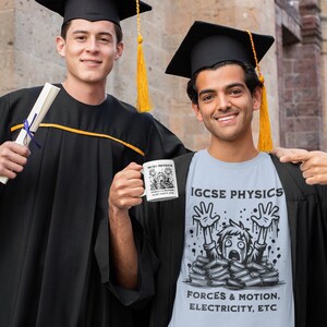 Puede incluir: Dos personas con gorros y batas de graduación. Una persona sostiene un diploma y la otra sostiene una taza blanca con una ilustración de dibujos animados de una persona enterrada bajo libros. La taza dice "IGCSE Physics Forces & Motion, Electricity, etc."