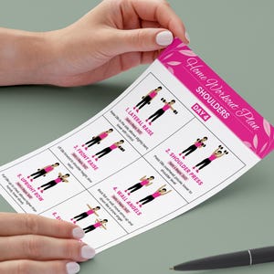 Puede incluir: Un "Home Workout Plan" rosa y blanco para hombros, sostenido por manos. El plan incluye ilustraciones de ejercicios como elevaciones laterales, press de hombros y &aacute;ngeles de pared. El texto dice "DAY 4".