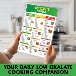 May include: A food list titled "LOW OXALATE FOOD LIST" in a clear plastic cover, held in front of a kitchen. The list is divided into green, yellow, and red sections. The bottom of the image reads "YOUR DAILY LOW OXALATE COOKING COMPANION."