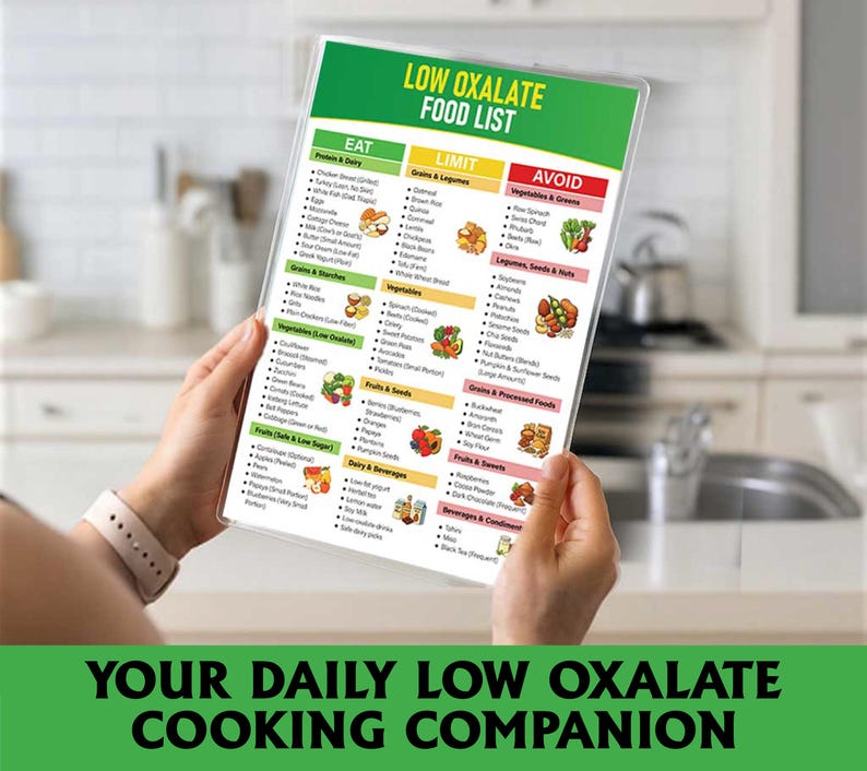 May include: A food list titled "LOW OXALATE FOOD LIST" in a clear plastic cover, held in front of a kitchen. The list is divided into green, yellow, and red sections. The bottom of the image reads "YOUR DAILY LOW OXALATE COOKING COMPANION."