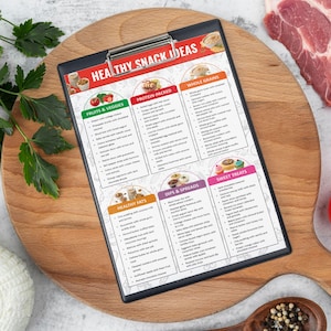 May include: A printable checklist with the title "Healthy Snack Ideas" divided into six categories: Fruits & Veggies, Protein Packed, Whole Grains, Healthy Fats, Dips & Spreads, and Sweet Treats. The checklist is printed on a white sheet of paper and is on a wooden cutting board.