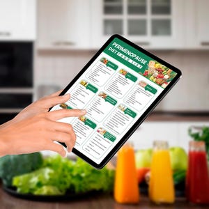 May include: A digital tablet displaying a list of foods for a perimenopause diet. The list is divided into categories such as "Fruits & Vegetables", "Protein", and "Healthy Fats".