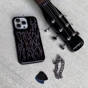 Black phone case with cyber cigilism designs that look chrome silver and metal to create an edgy gothic design
