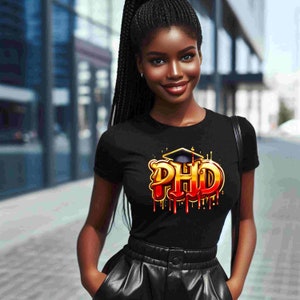 May include: Black t-shirt featuring the word "PHD" in gold and red, with a graduation cap design. The shirt has short sleeves.