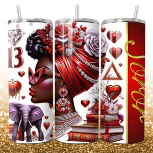 Peut inclure: Un gobelet rouge et or avec un motif représentant une femme noire avec des lèvres rouges et un turban rouge, un cœur rouge, un diamant et le chiffre 13. Le gobelet a également une pile de livres et un éléphant.